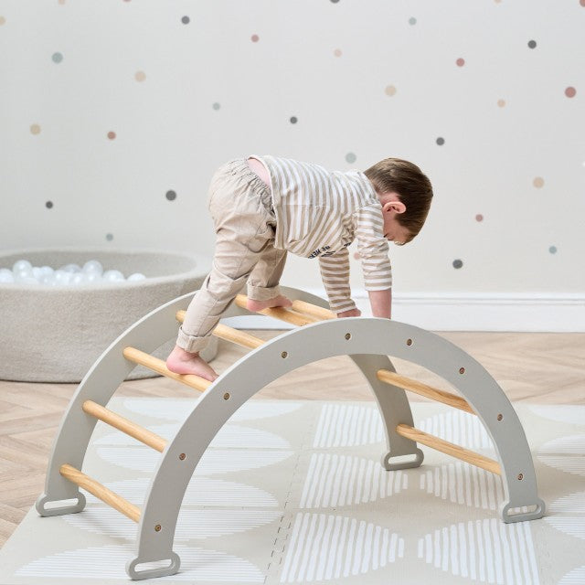 Boy playing on the Scala Arch in Mushroom. Play arch designed for climbing, balance, and imaginative play