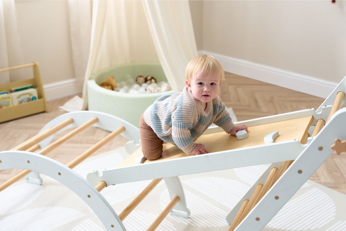 Child playing on a wooden climbing toy in a nursery