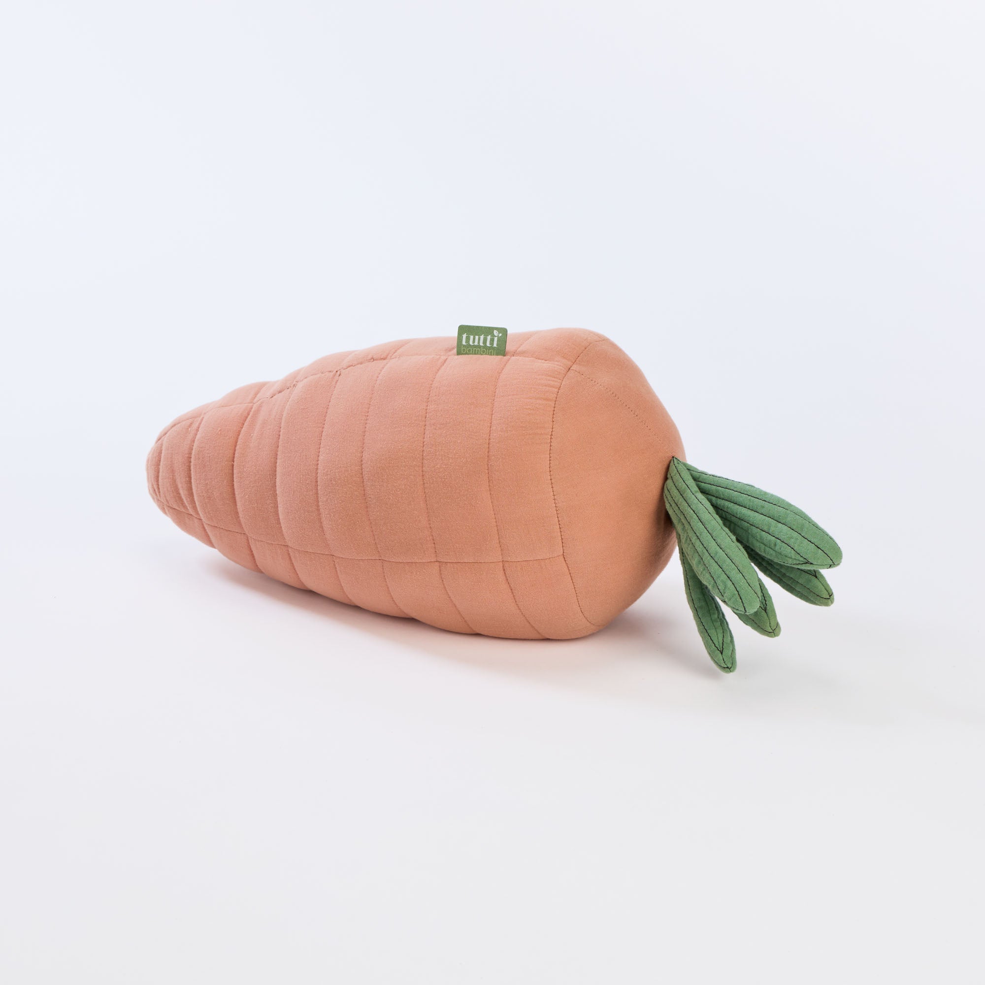 Cutout view of the Soft Muslin Carrot Cushion with quilted peach body and green leaf top
