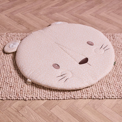 Round Larry Leopard baby playmat in soft beige print with ears and embroidered face, placed on textured rug.