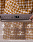 Close-up of CoZee Sense bedside crib control panel showing 20°C with white noise, lullabies and cry sensor features.