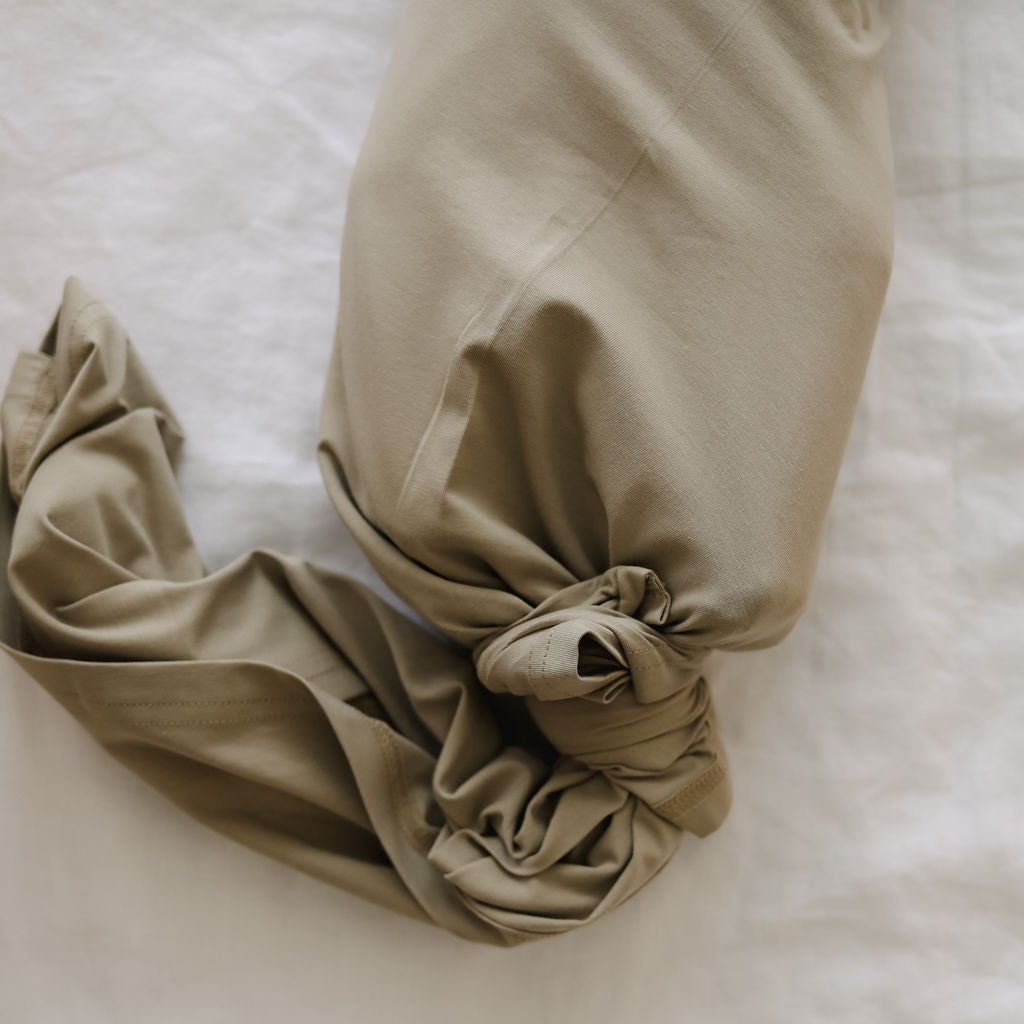 Beige swaddle with a knotted top on a light background