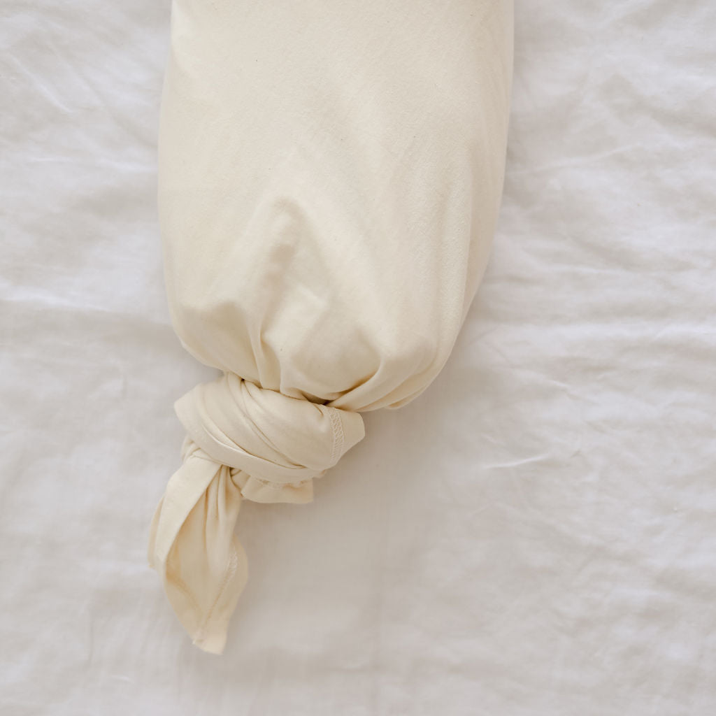Beige swaddle tied with a knot on a white background