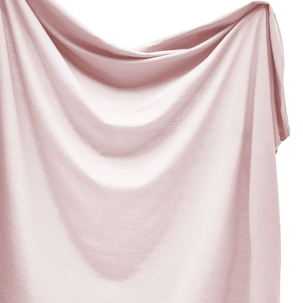 Pink swaddle draped over a white background