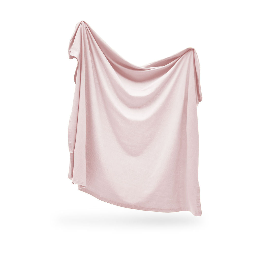 Pink swaddle draped over a white background