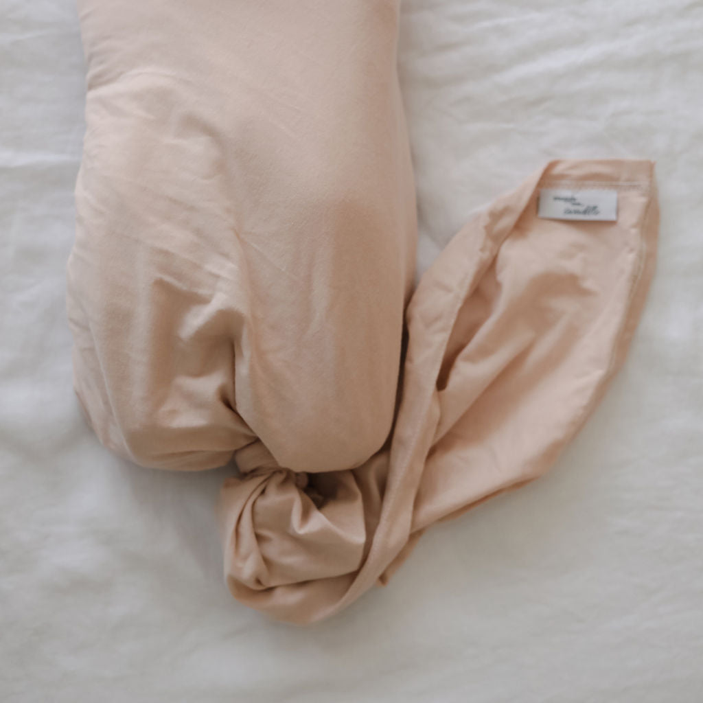 Light pink swaddle with a knotted top on a light background