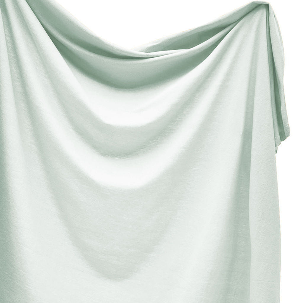 Light green swaddle draped over a white background