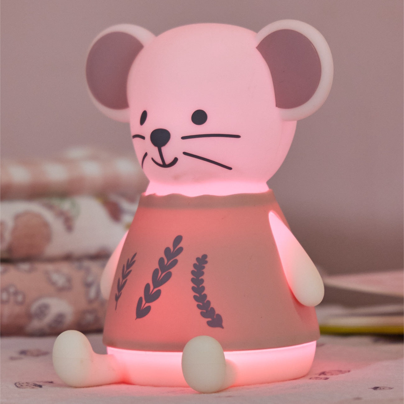 Margot Mouse pink mouse-shaped night light on a wooden surface with a soft pink background