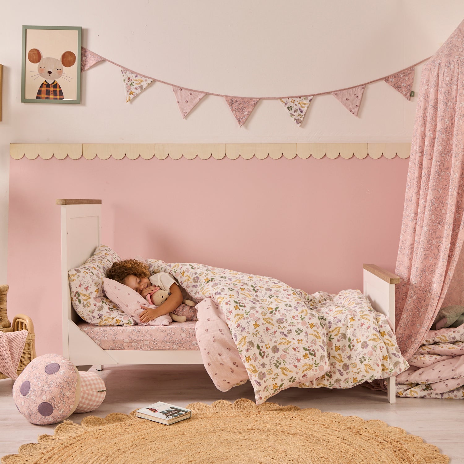 Child sleeping in a cot bed with floral bedding in a cosy bedroom setting.