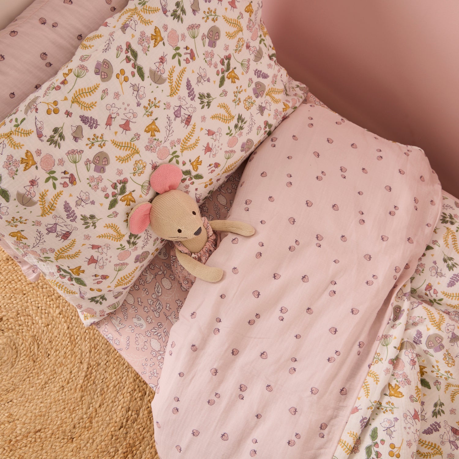 Floral-patterned cot bed duvet set with a soft toy on a cot bed