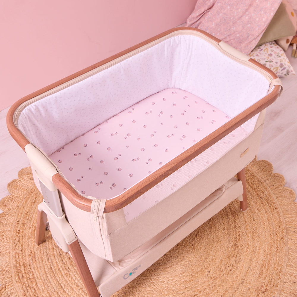 Baby crib with pink mattress cover in a room setting