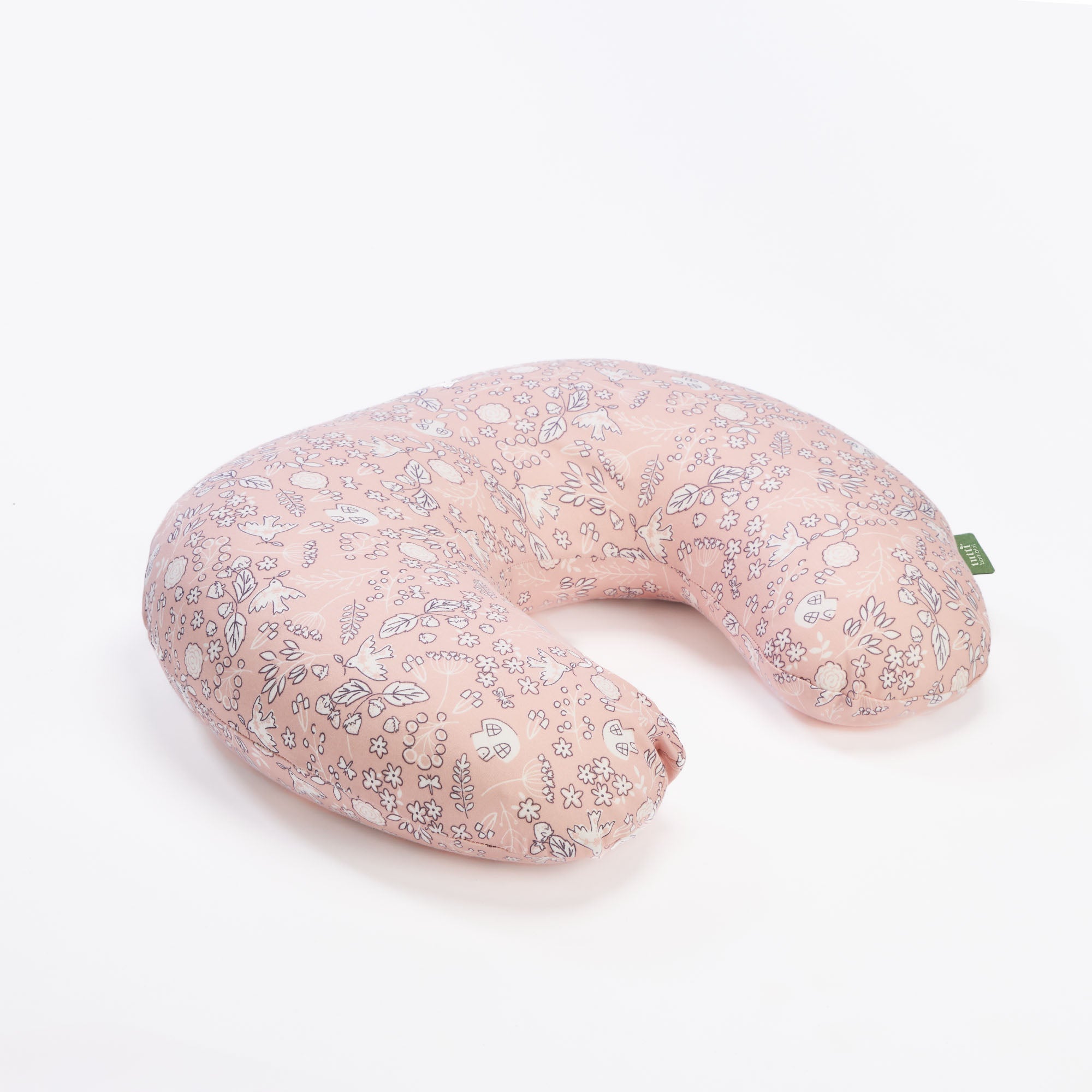 Tiny Tails feeding pillow in soft pink woodland print, shown in cutout view emphasising its ergonomic curve and plush support.