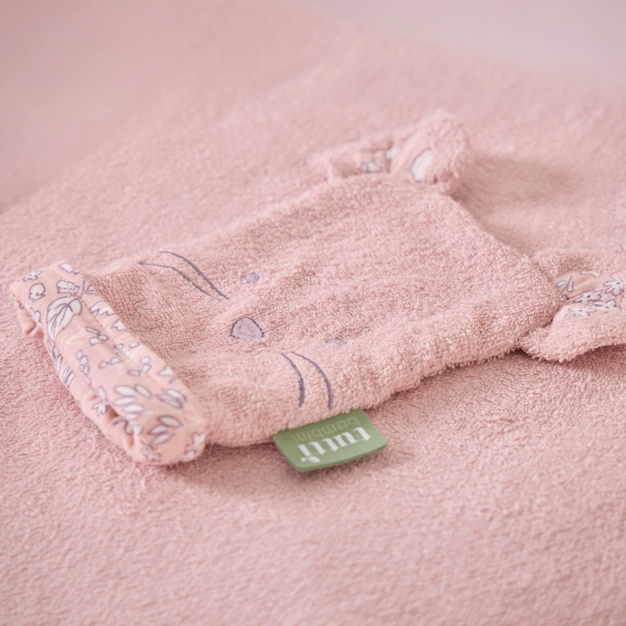 Pink bunny-shaped wash mitt on a pink background