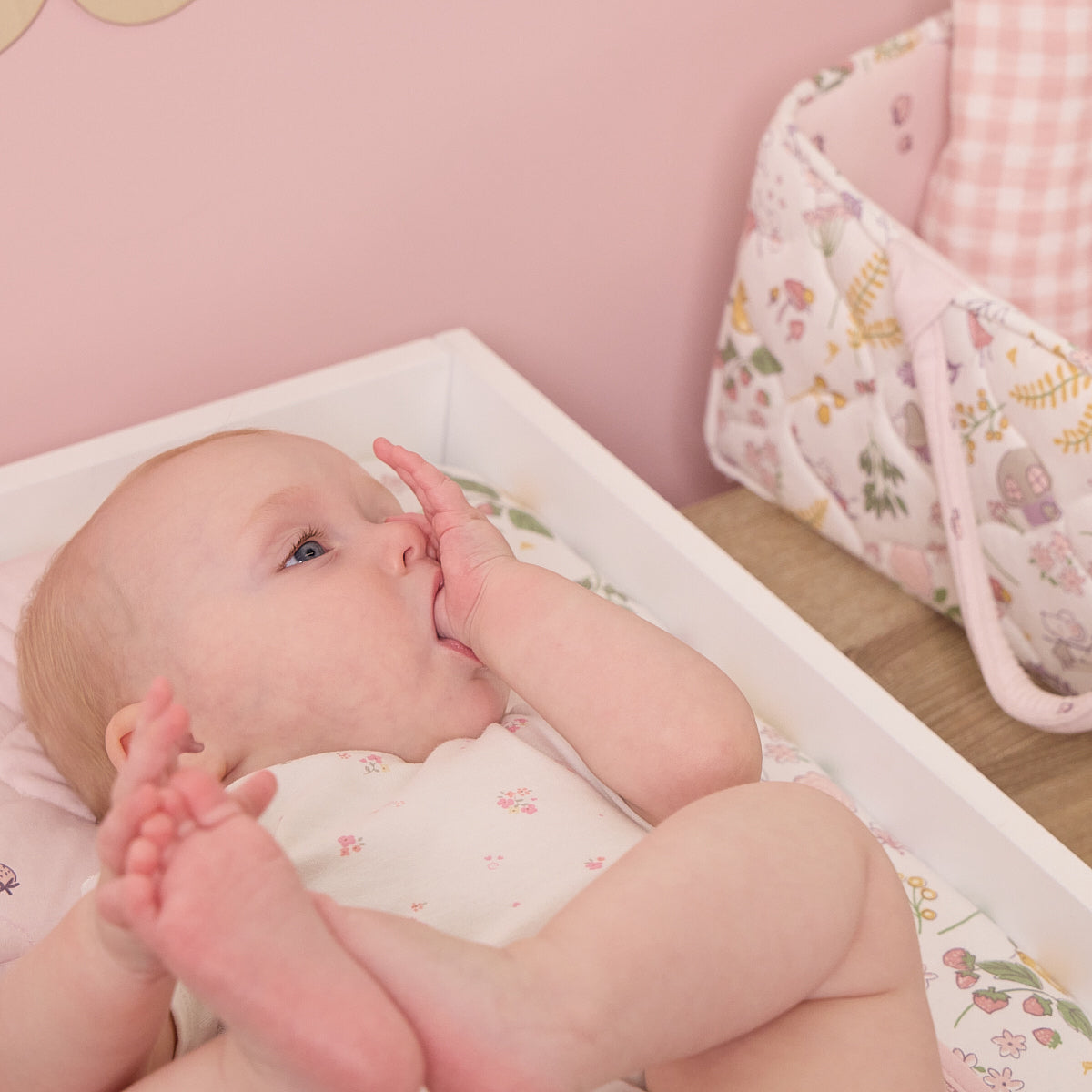Baby lying on a changing table with the Tiny Tails luxury changing mat.
