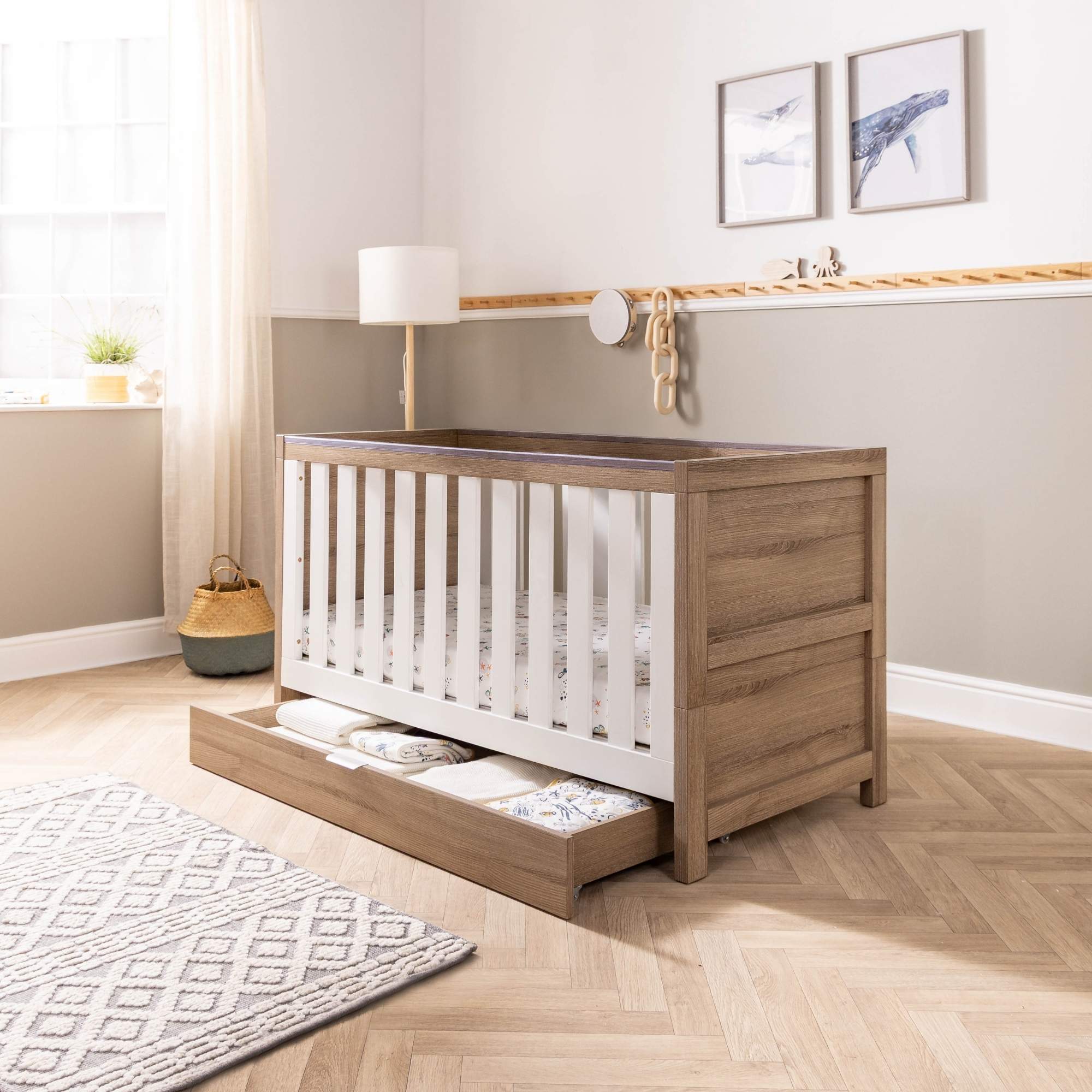 Modena cot bed with underbed storage drawer opened in a nursery setting