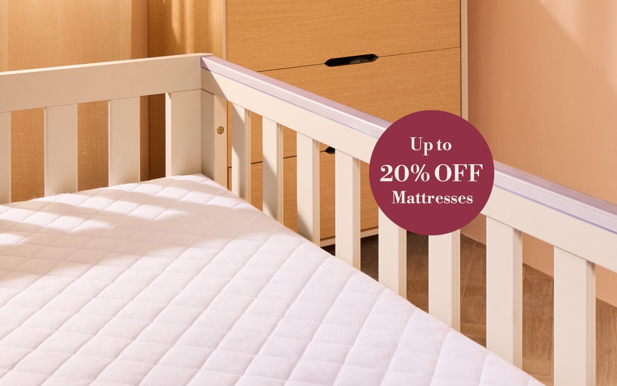 Cot with mattress and wooden cabinet in the background, promotional text overlay.