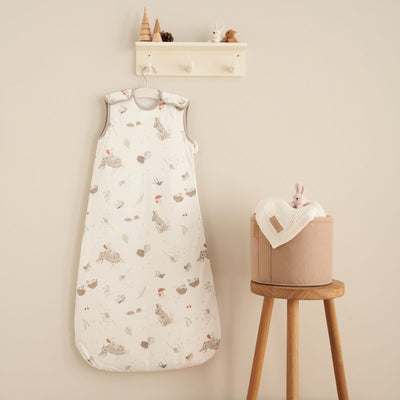 Cocoon print baby sleep bag 0-6 months hanging on nursery peg rail beside toys, creating a cosy, woodland-themed sleep space.