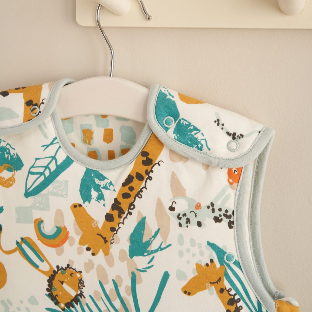 Close-up of Run Wild 0-6 month baby sleep bag shoulder popper with safari print for easy nighttime changes