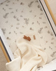 Overhead view of Cocoon bedside crib fitted sheet, organic cotton with woodland animal prints providing softness and a snug sleep fit