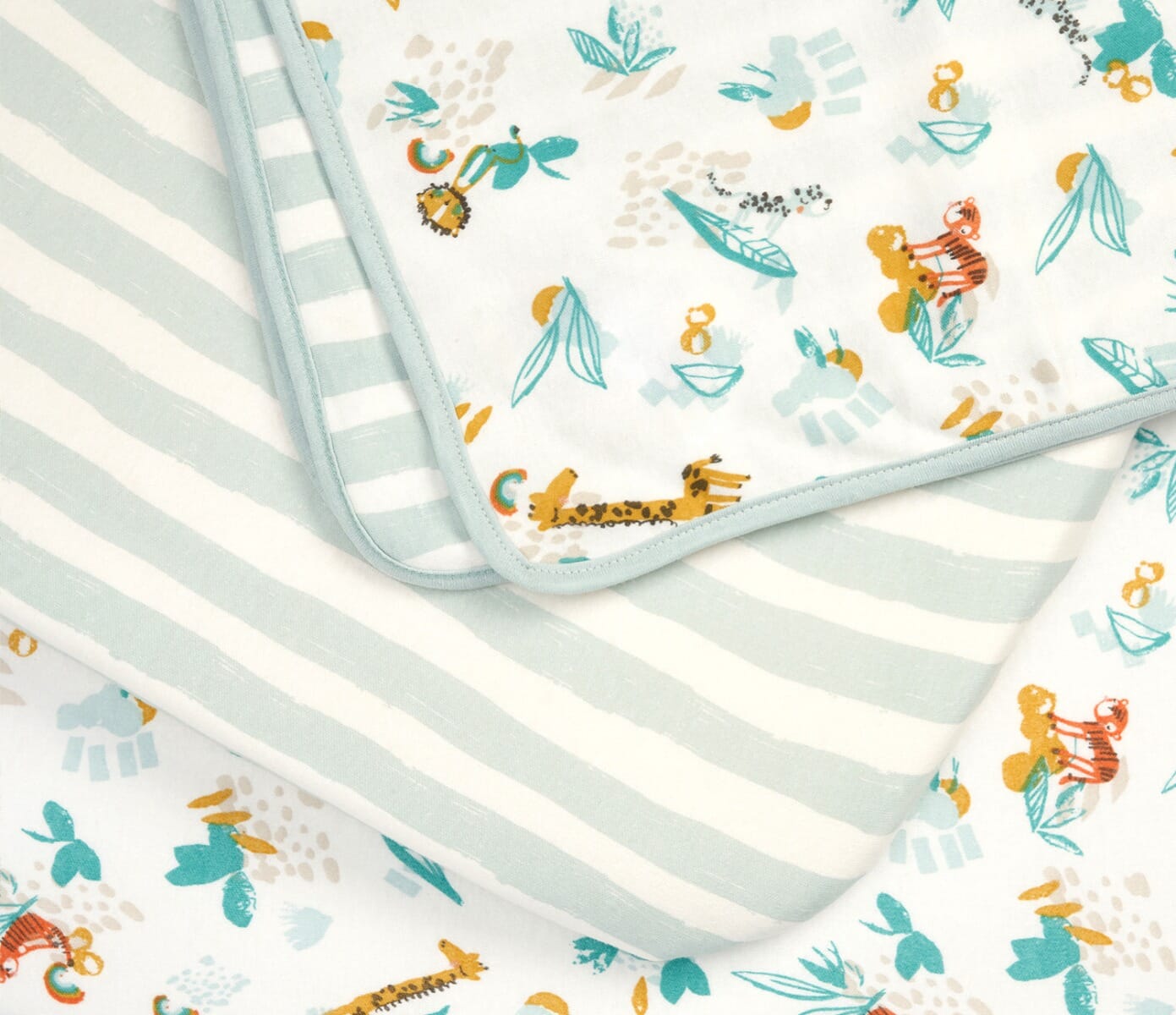 Close-up of Run Wild fitted sheets featuring safari animals and pastel stripes, highlighting the soft cotton finish and vibrant, child-friendly design