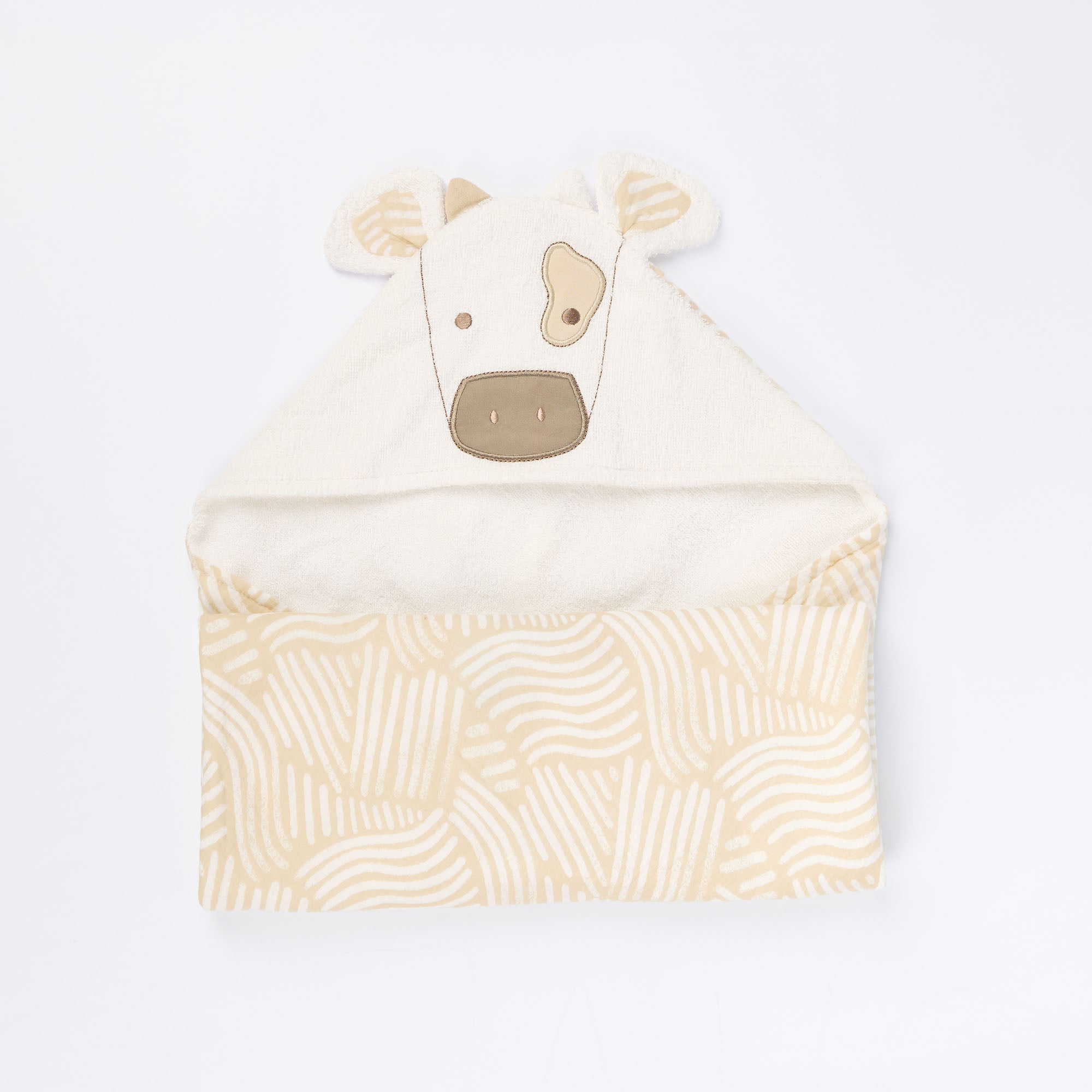 Cutout of Clemi the Cow hooded towel in soft terry fabric, featuring embroidered cow face, horns, and patterned detailing