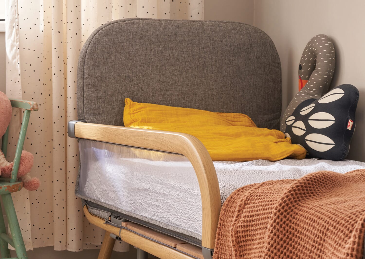 Close-up of the CoZee XL toddler bed in oak and grey, styled with cosy layered bedding and soft cushions for a warm, inviting sleep space