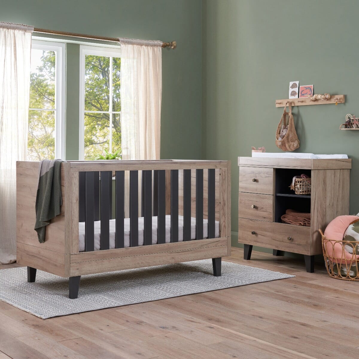 Lifestyle view of the Como cot bed and chest changer in distressed oak and slate grey, creating a warm, modern nursery with soft natural tones