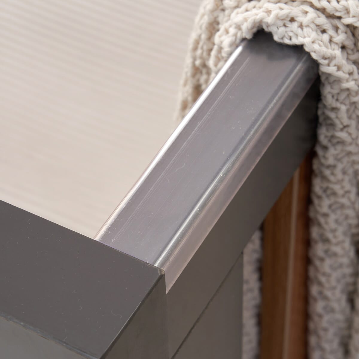 Detail of the teething rail of the Como cot bed in slate grey and rosewood