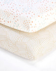 Close-up of cot bed fitted sheets in Good Life print, featuring soft neutral tones with playful carrot and abstract patterns.