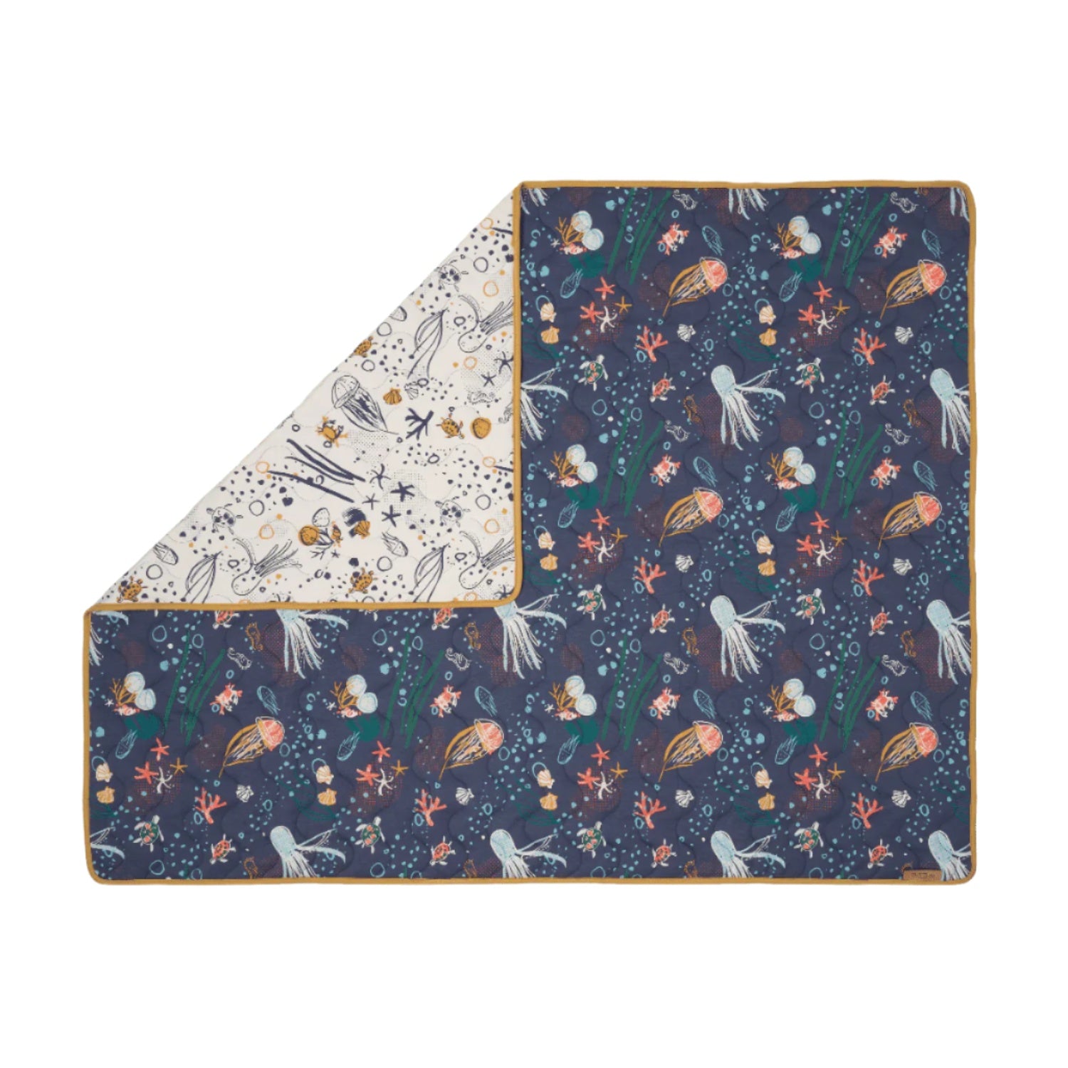 Folded corner cutout of Our Planet coverlet, reversible quilted cotton with ocean designs and mustard trim for a versatile nursery look