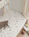 Lifestyle view of cot fitted sheet in Cocoon design with playful woodland animal prints, made from soft cotton for a snug and cosy nursery setting