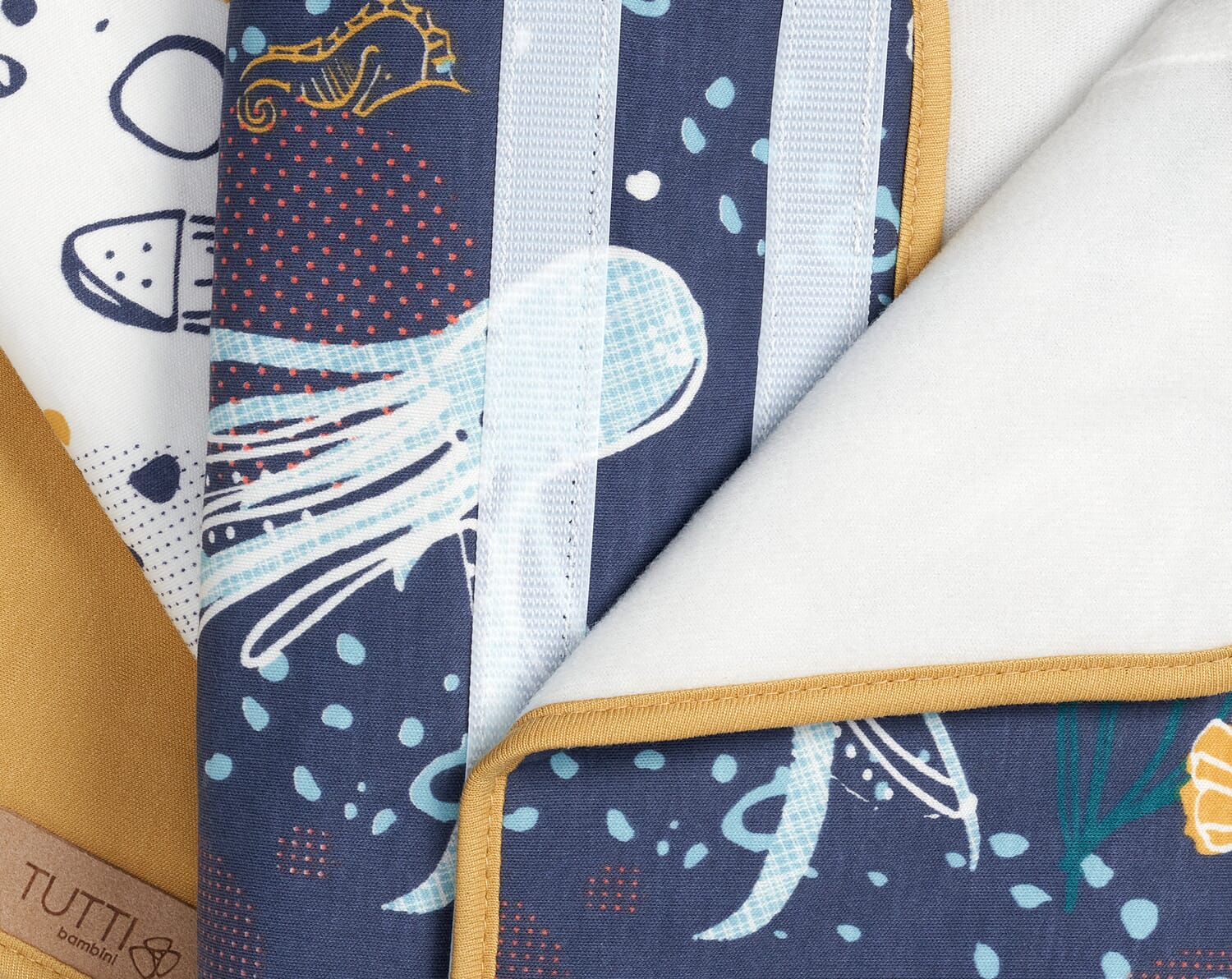 Close-up of Our Planet cot wrap showing secure velcro fastening, padded structure and playful ocean-inspired print