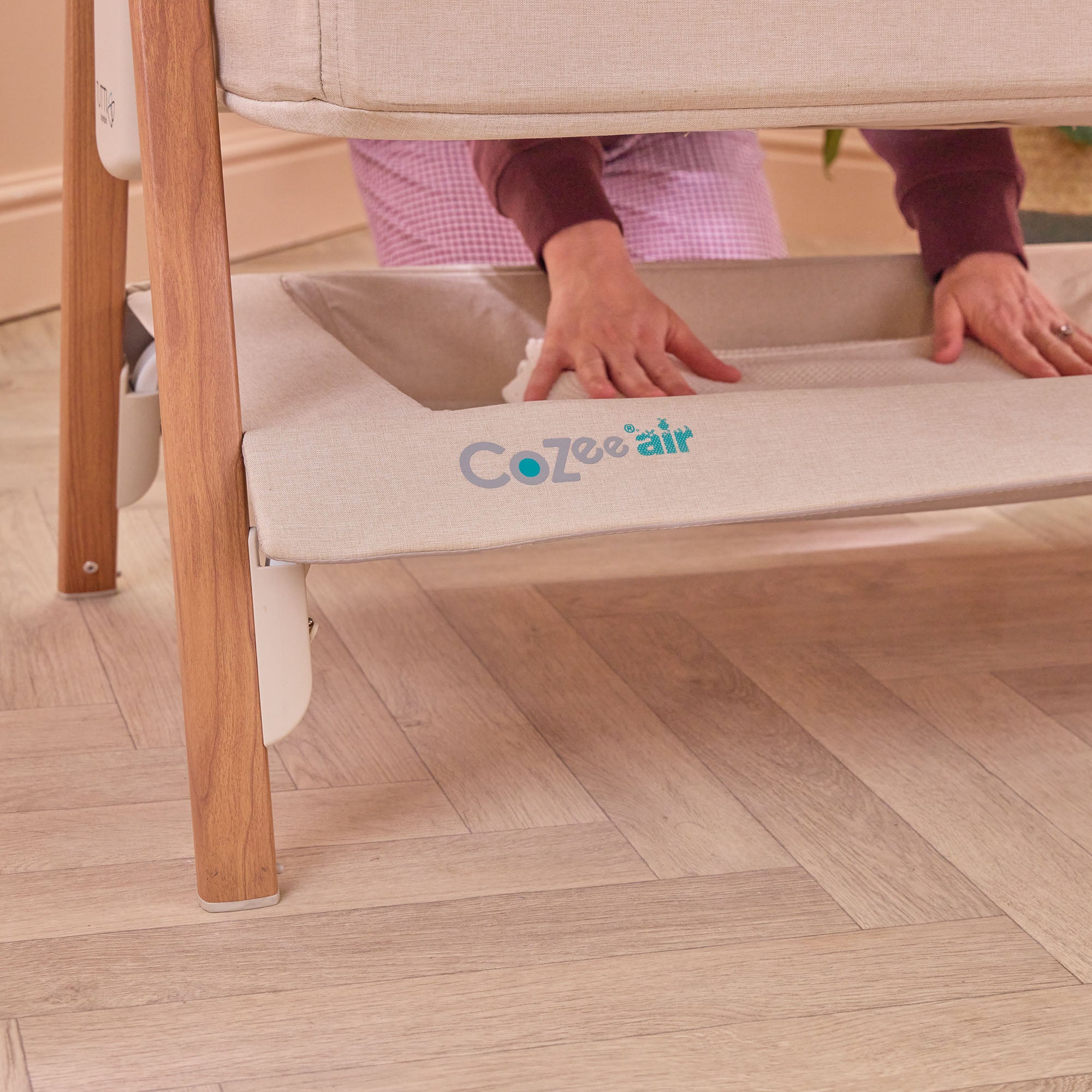 CoZee Air in Scandinavian and Ecru with under-crib storage basket – lifestyle image showing space for baby essentials