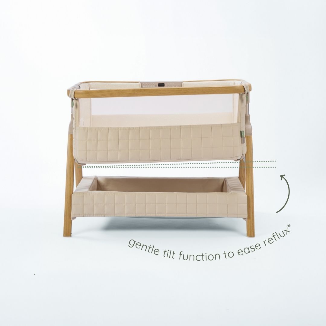 CoZee Sense bedside crib in toasted oak and sand showing gentle tilt function designed to help ease reflux.