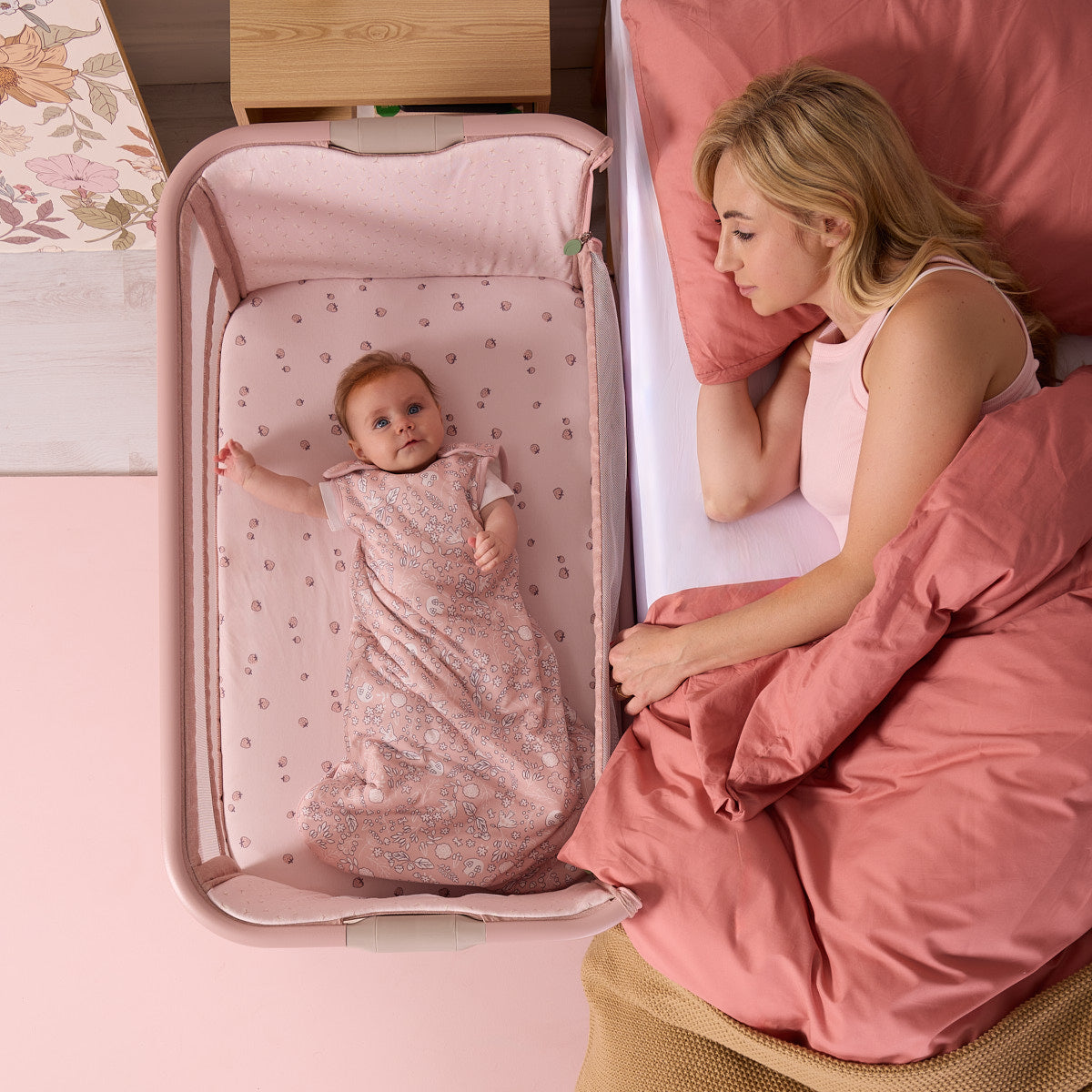 baby resting peacefully in the cozee zen in blush with mum to the side showing easy co-sleeping functionality