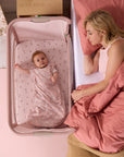 baby resting peacefully in the cozee zen in blush with mum to the side showing easy co-sleeping functionality