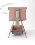 CoZee Zen bedside crib in blush showing 6-step height adjustment with adjustable legs and integrated storage shelf.