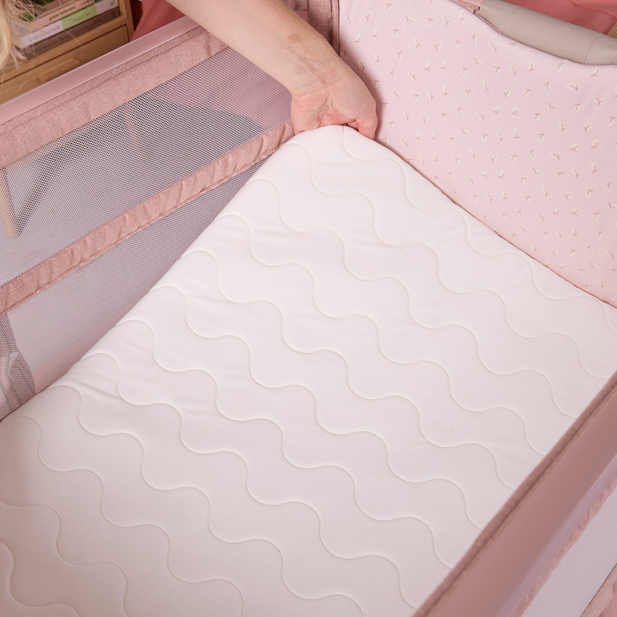 hand propping up the mattress of the cozee zen to sow its softness and padded comfort