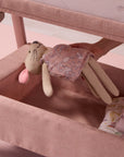 image showing a toy being placed in the spacious storage underneath the cozee zen in blush