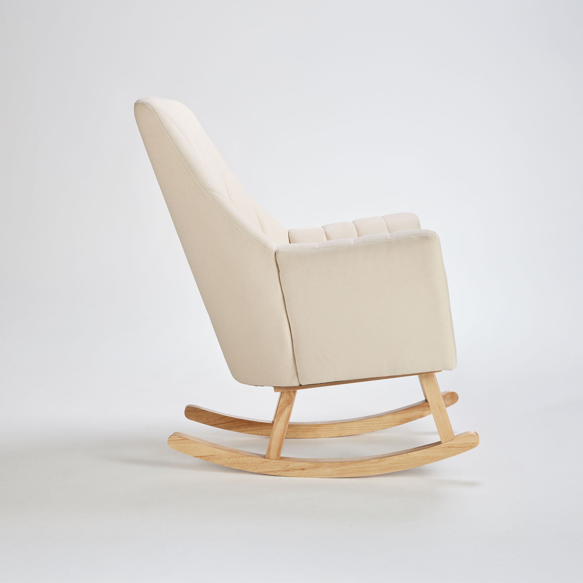 Side profile of the Danica rocking chair in cashmere fabric, featuring fluted backrest, deep seat, and solid wooden frame