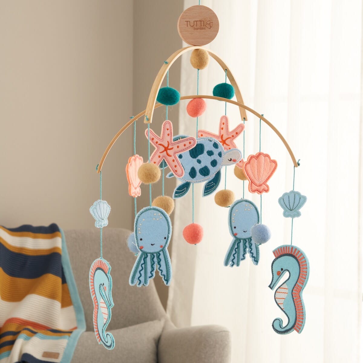 Our Planet felt nursery mobile styled above a chair, featuring sea creatures and soft felt textures to create a calming, ocean-inspired space