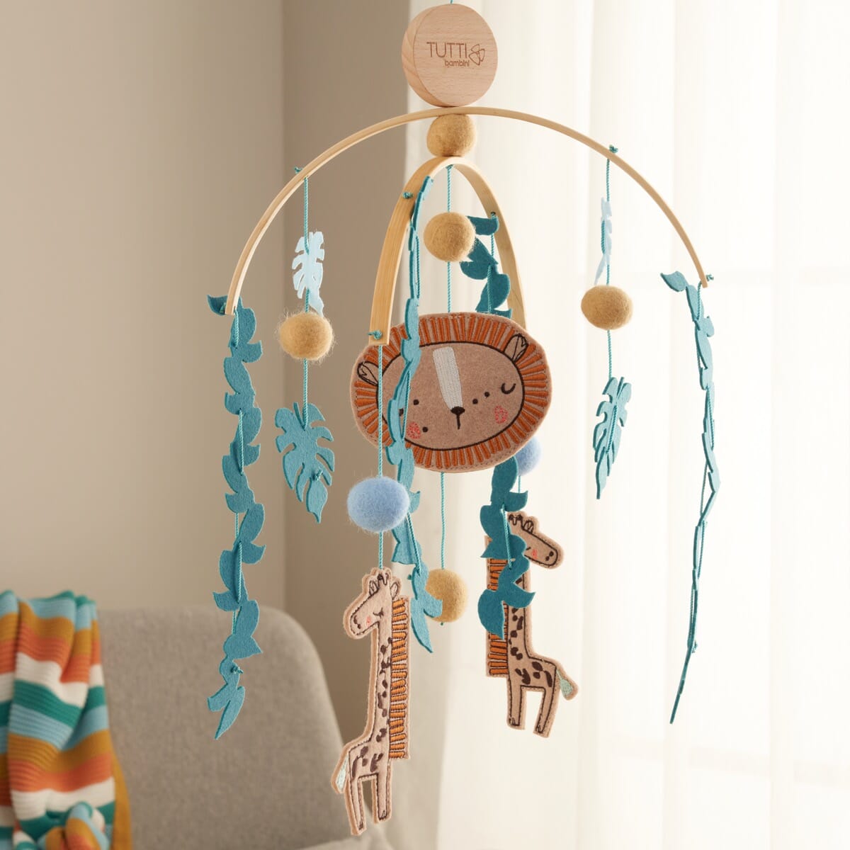 Full view of the Run Wild felt nursery mobile with hanging animal shapes, felt balls and wooden frame, designed to gently soothe baby