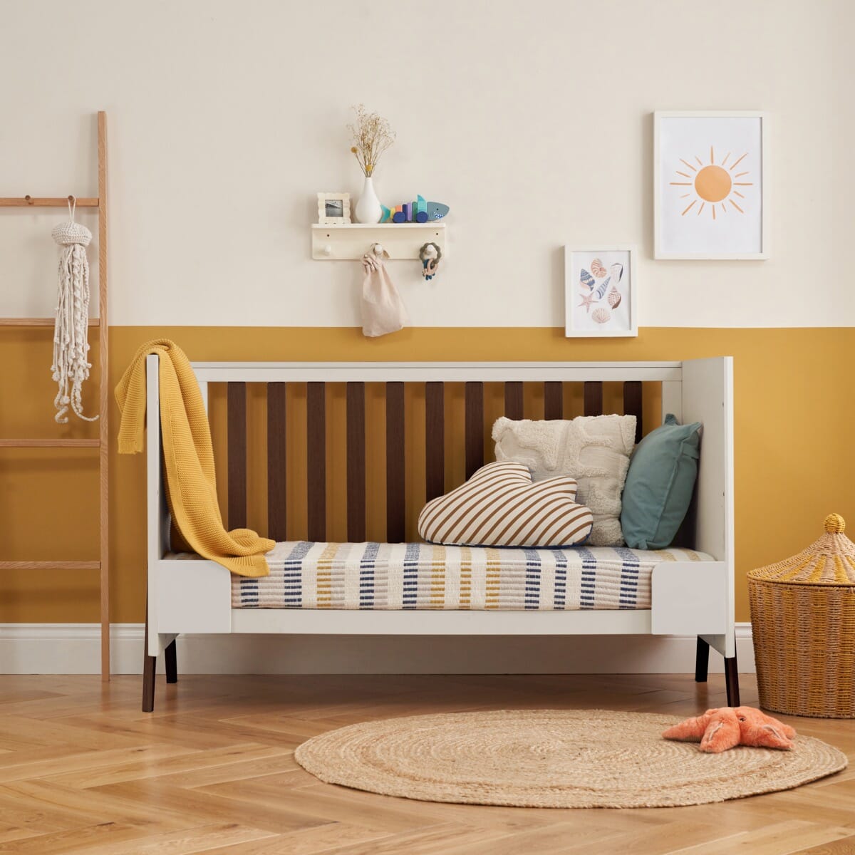 fuori cot bed in white sand and warm walnut shown in sofa bed mode for relaxed parent and child reading and bonding moments.