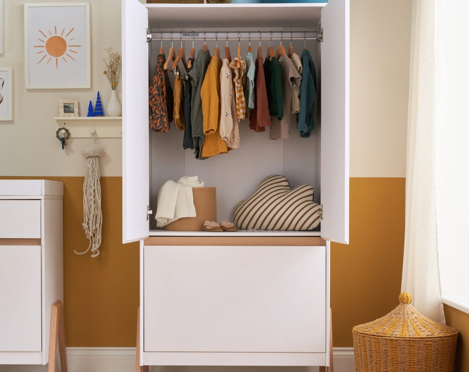 Lifestyle view of the Fuori wardrobe with doors open, showing hanging rail and storage space in a softly styled white and light oak nursery