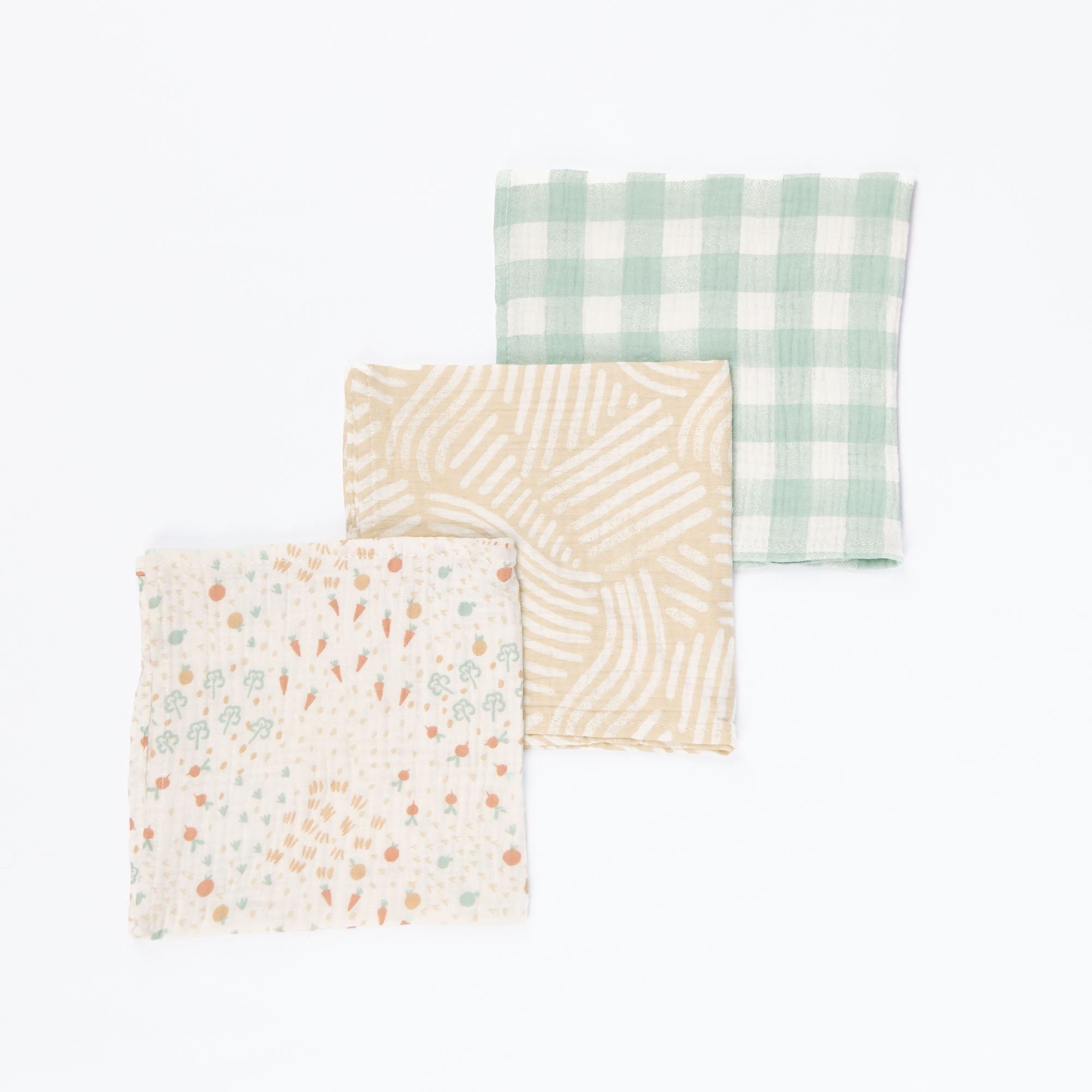 Flat lay of three Good Life large muslin square swaddles in coordinating neutral prints, highlighting lightweight weave and generous size