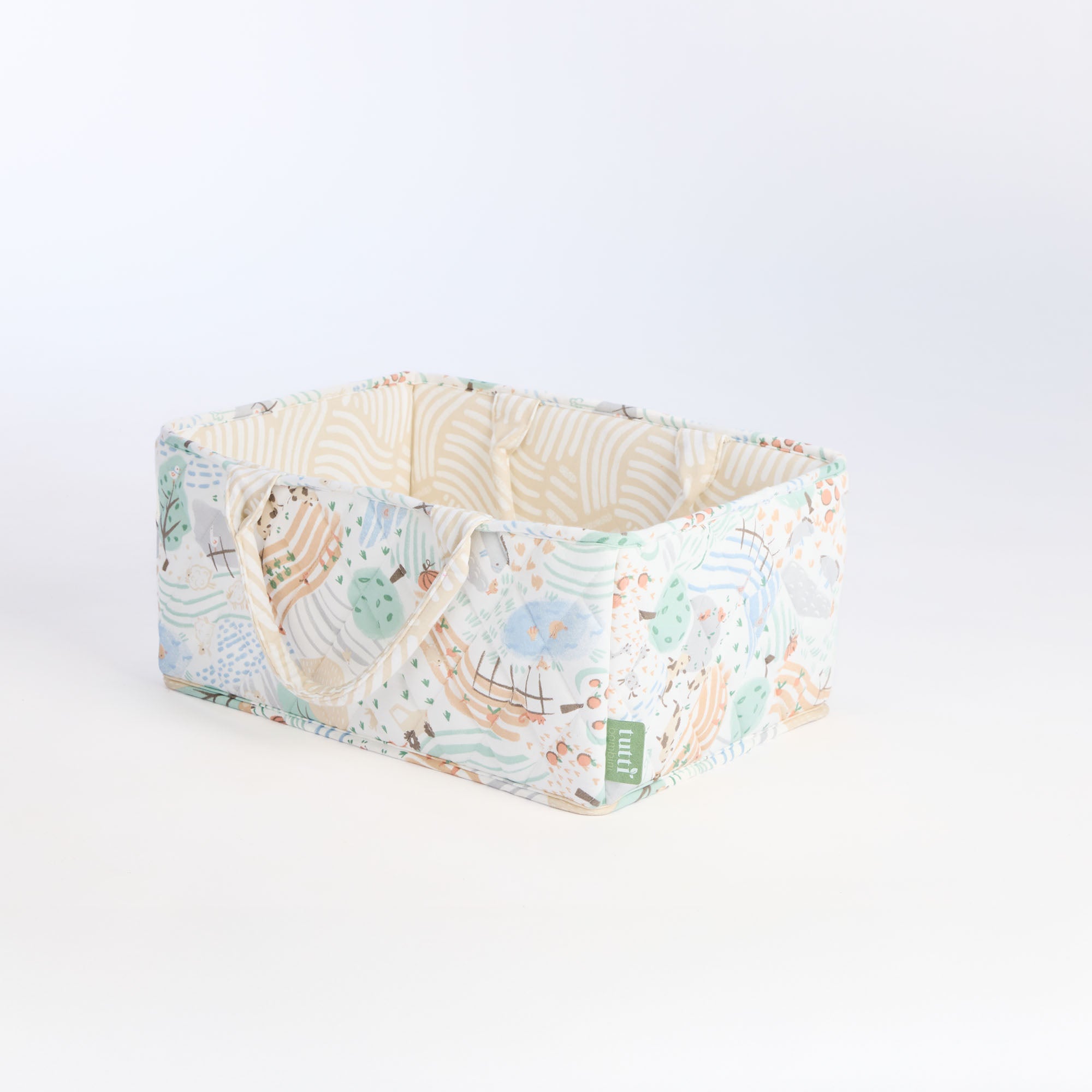 Angled cutout of the Good Life nappy caddy in countryside print with padded sides and neutral interior for stylish nursery storage