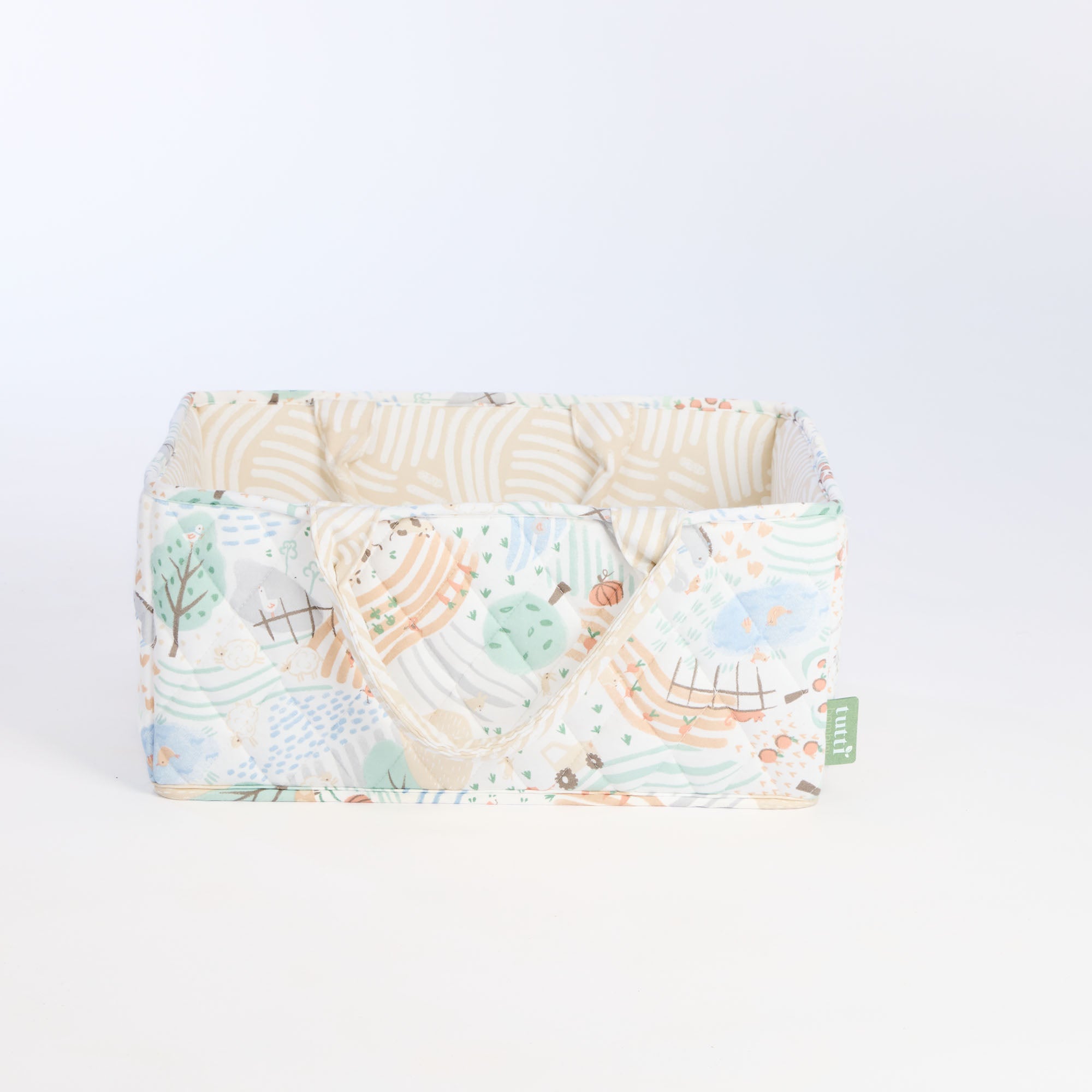 Cutout of the Good Life nappy caddy in countryside print, featuring quilted sides, soft neutral lining, and sturdy fabric handles