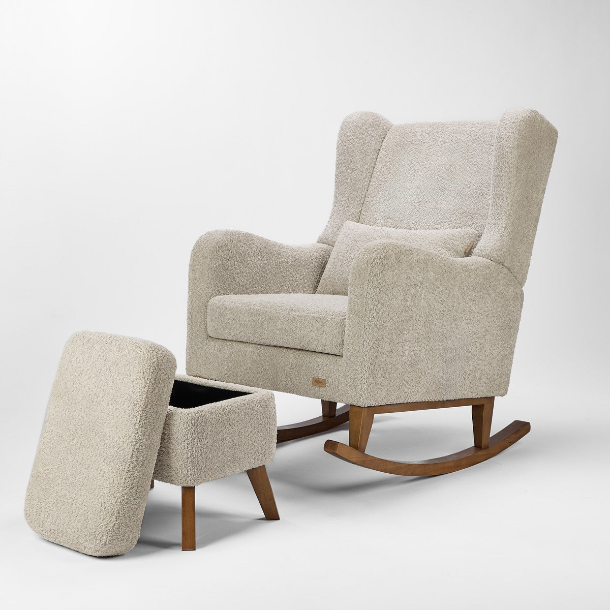 Cutout of the Harper Wingback rocking chair and footstool in teddy mushroom with footstool lid lifted to reveal hidden storage