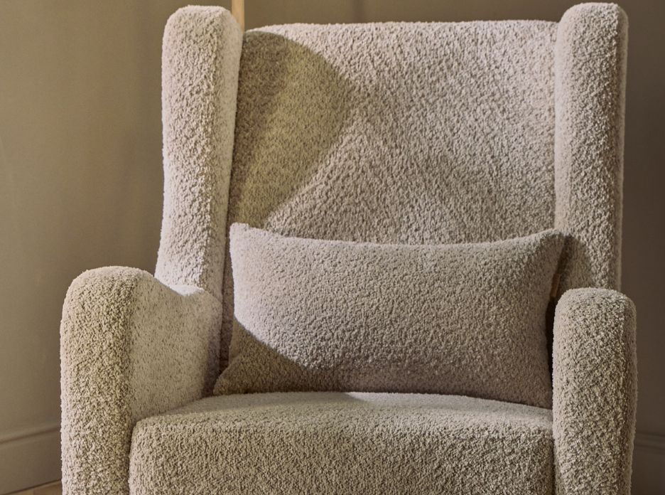 Soft boucle texture of the Oscar Luxe rocking chair in sage shown from the front, featuring the high backrest and plush lumbar cushion.