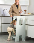 Toddler climbing up the Helping Hands Montessori Learning Tower in sea mist, demonstrating stable steps and safety handles for support